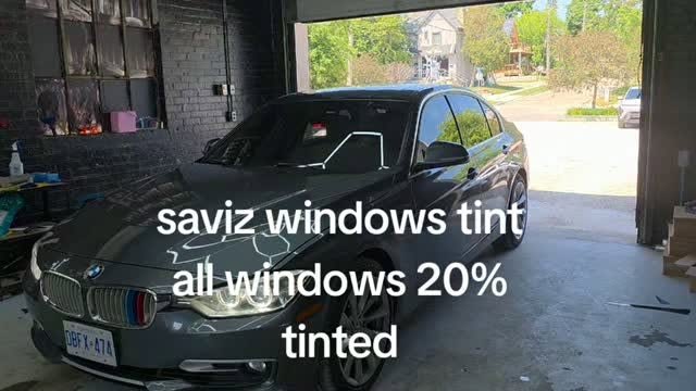 Black sedan with fresh window tint leaving the shop